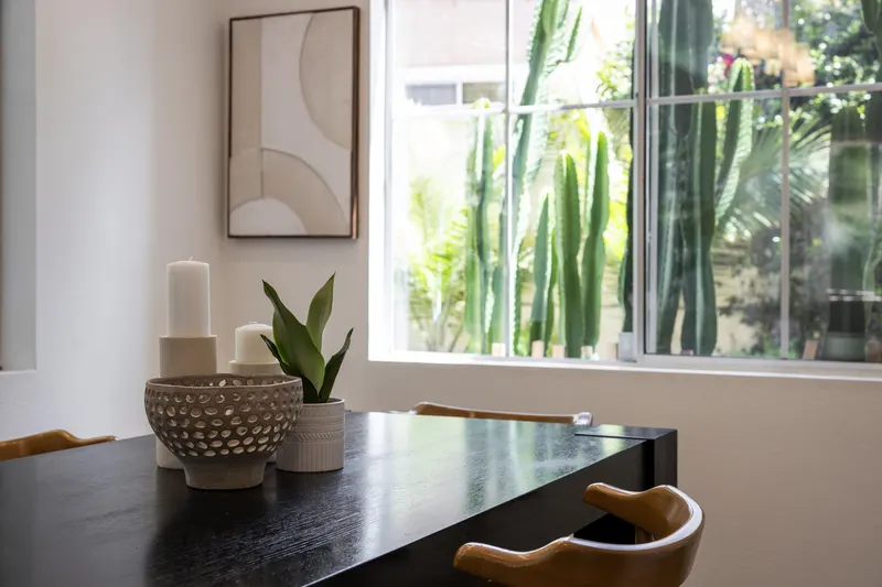 Dining room detail with textured ceramics beside a window framing mature cactus at 5353 Renaissance Ave San Diego