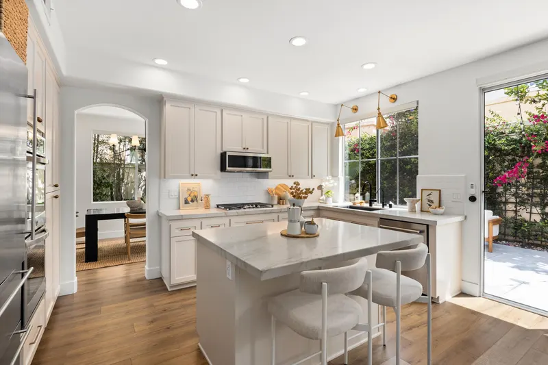 Kitchen island with counter seating and sliding door to the private backyard at 5353 Renaissance Ave San Diego