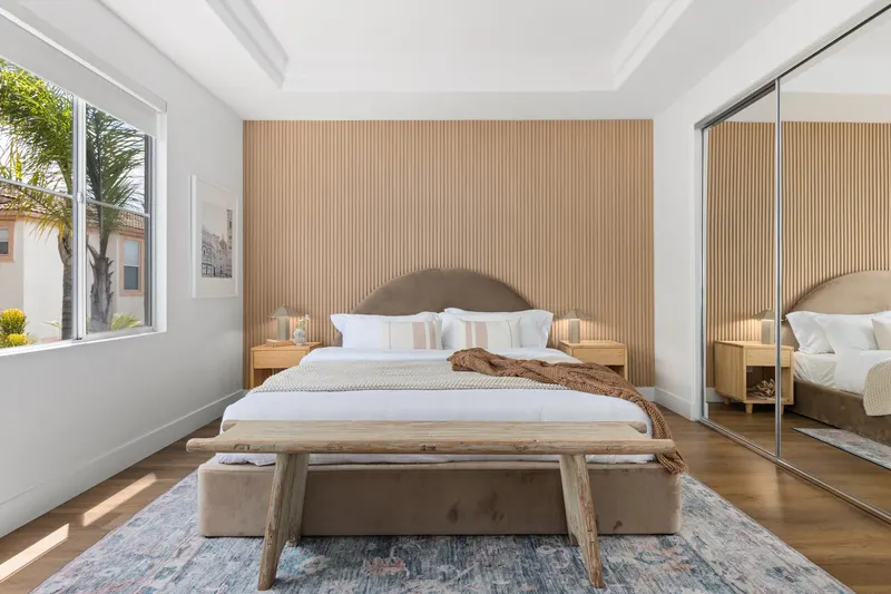 Primary bedroom wide view with mirrored closet doors and tray ceiling at 5353 Renaissance Ave San Diego