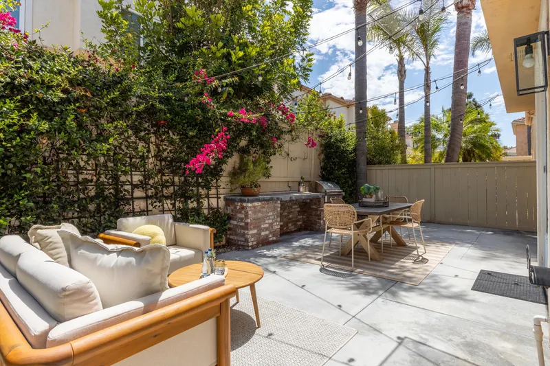 Outdoor lounge seating on the patio beneath bougainvillea and mature trees at 5353 Renaissance Ave San Diego