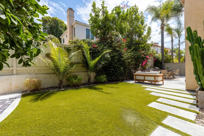 Wide backyard view with palms, pavers and lush privacy planting at 5353 Renaissance Ave San Diego