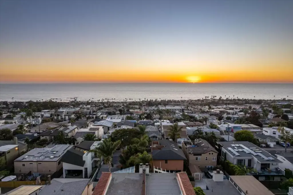 Panoramic sunset view over a coastal residential neighborhood leading to the Pacific Ocean horizon in Cardiff-by-the-Sea.