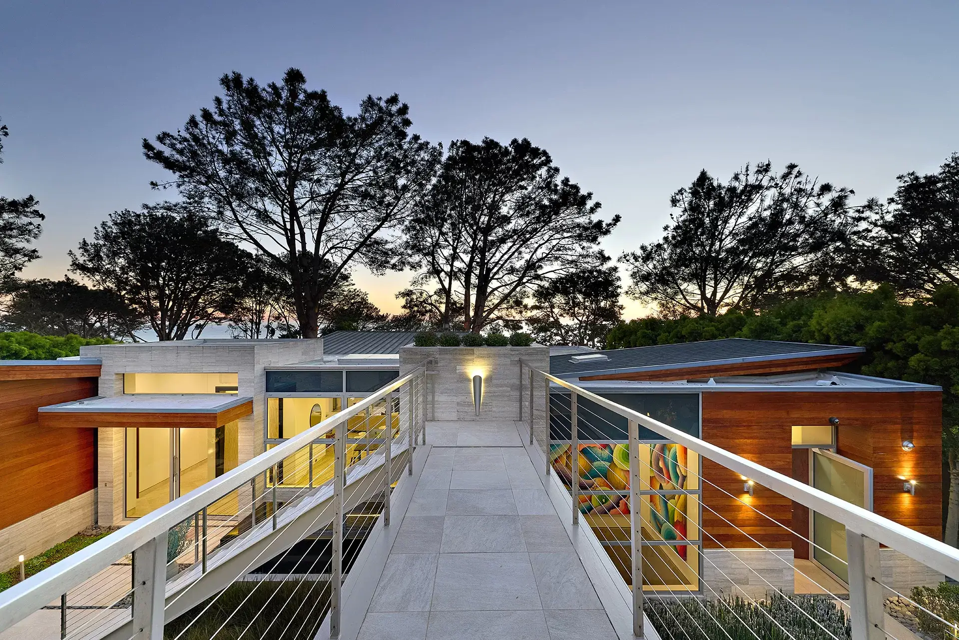 Bridge entry spanning infinity-edge pool at 116 Nob Ave Del Mar luxury home with Torrey Pines at dusk listed by Kelli Miller Compass
