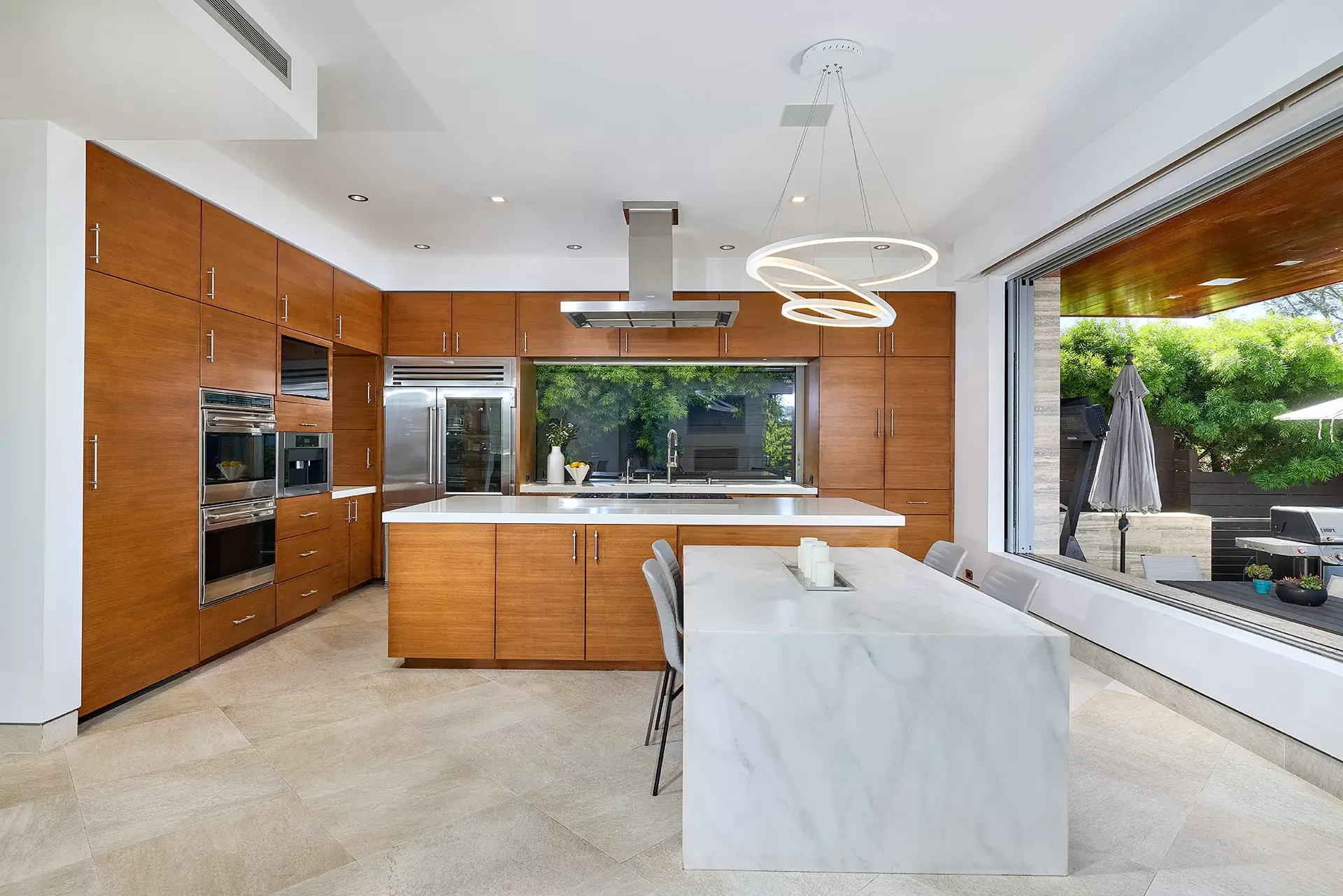 Chef's kitchen with Wolf 8-burner range Sub-Zero refrigerator waterfall marble island and walnut cabinetry at 116 Nob Ave Del Mar listed by Kelli Miller Compass