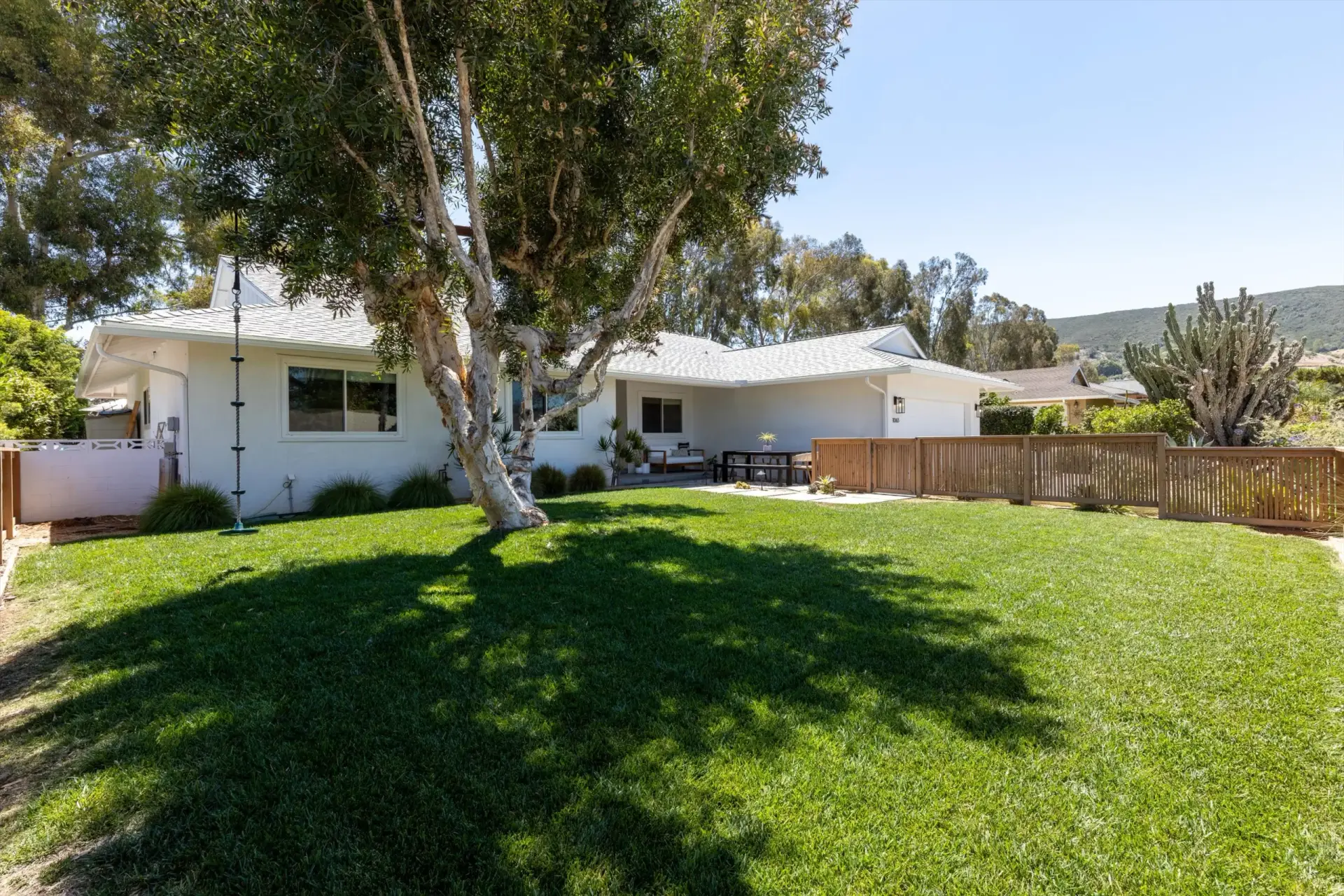 Front yard lawn with shade tree, tree swing and hill views at 1063 San Julian Dr San Marcos listed by Kelli Miller Compass