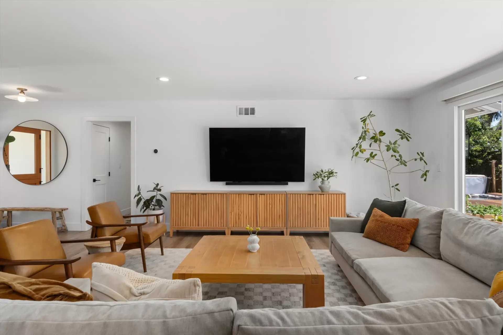 Living room with media console and 13' LaCantina Doors open to the back patio at 1063 San Julian Dr San Marcos listed by Kelli Miller Compass