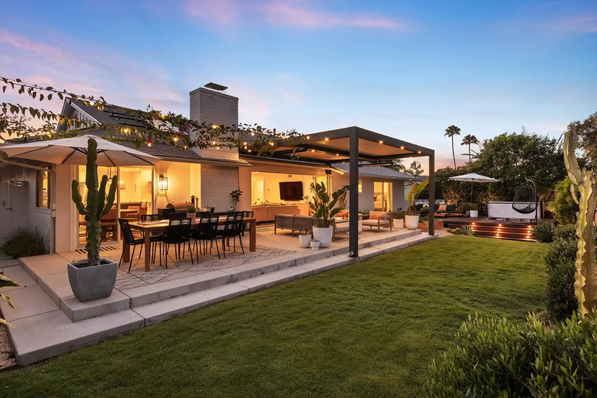 Twilight backyard with covered lounge, dining patio and lawn at 1063 San Julian Dr San Marcos listed by Kelli Miller Compass