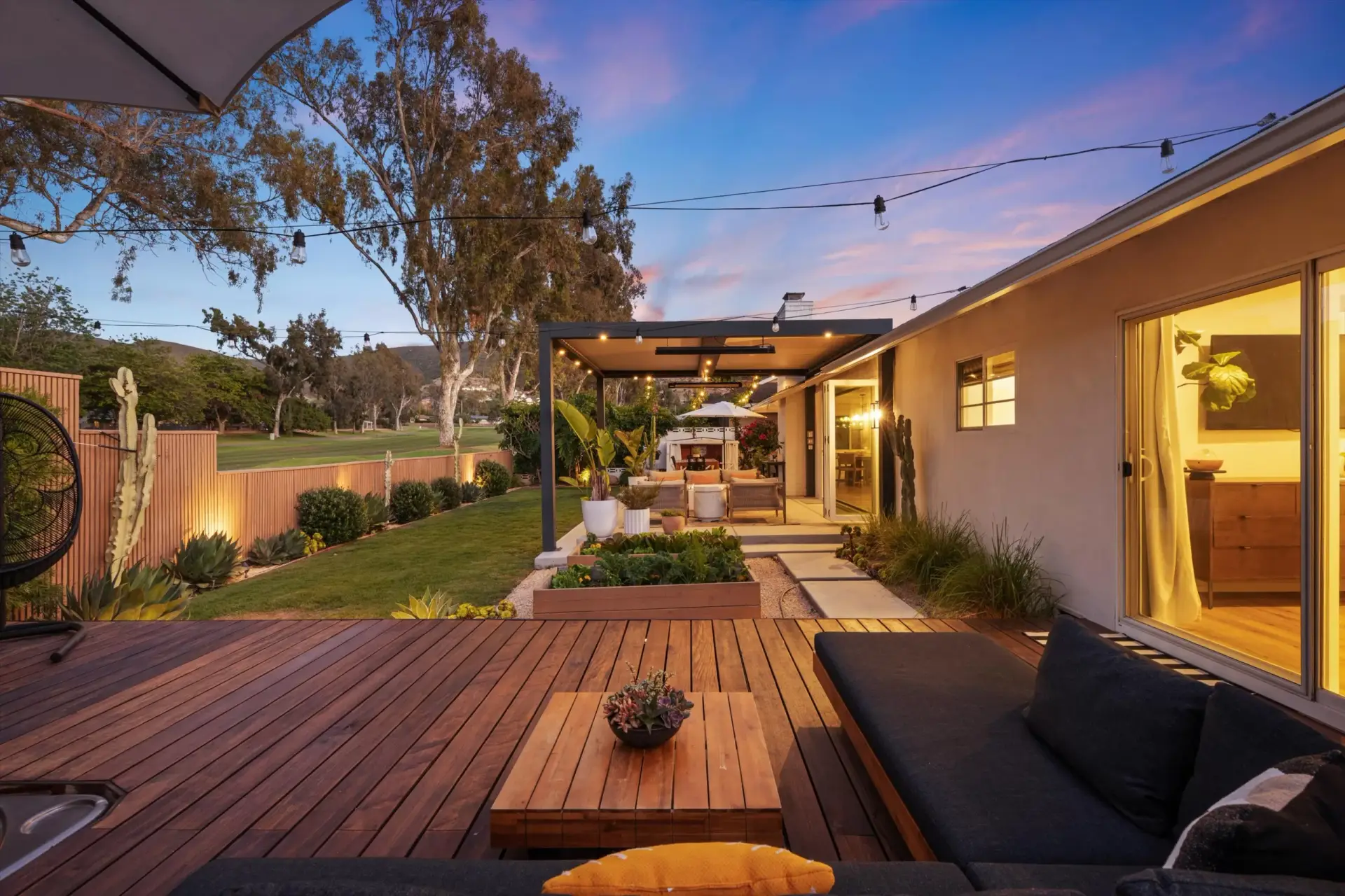 Covered outdoor lounge and backyard living space at twilight at 1063 San Julian Dr San Marcos listed by Kelli Miller Compass