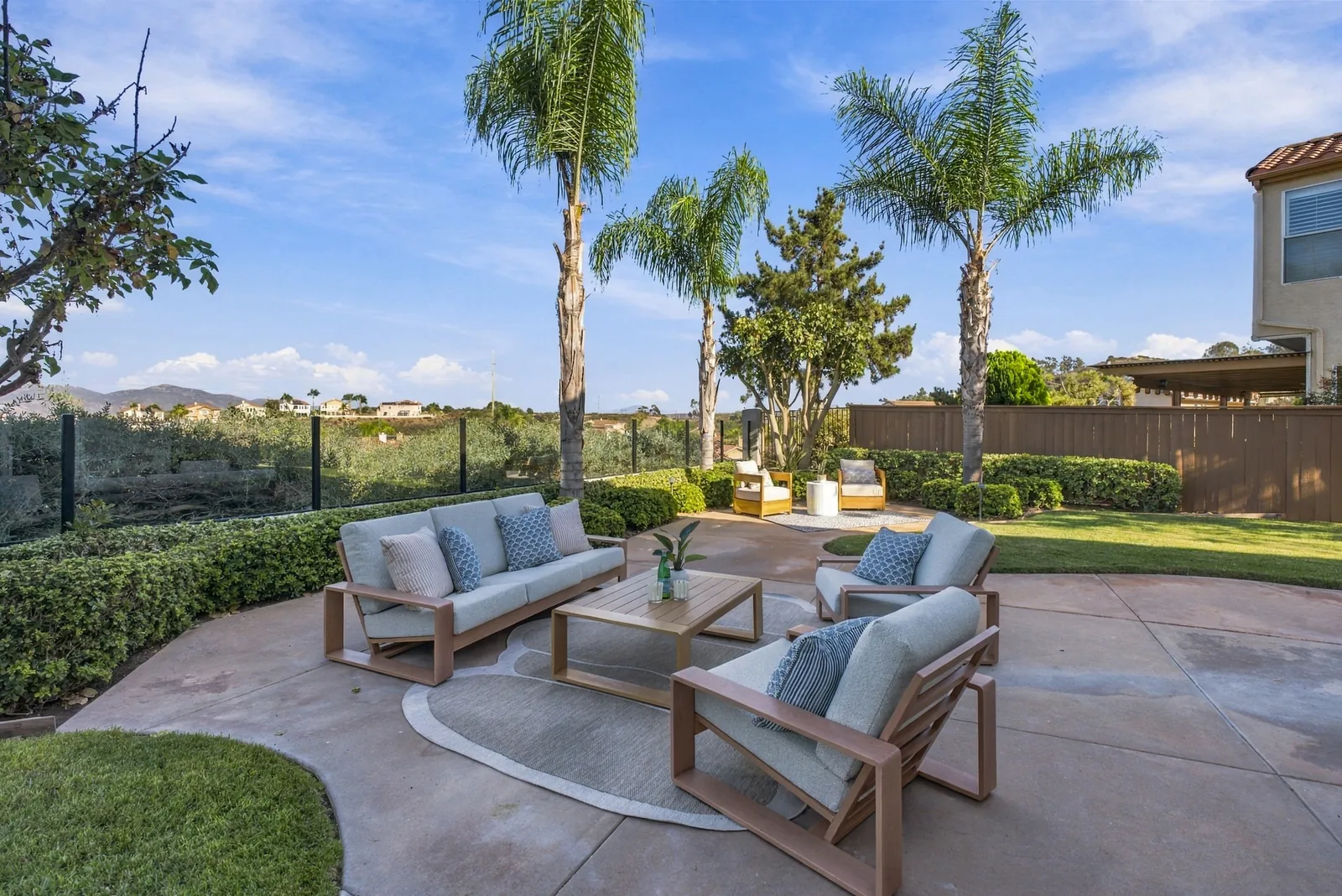 Outdoor lounge seating on the concrete patio with canyon views behind at 12086 Little Silver Ct, Scripps Ranch, San Diego