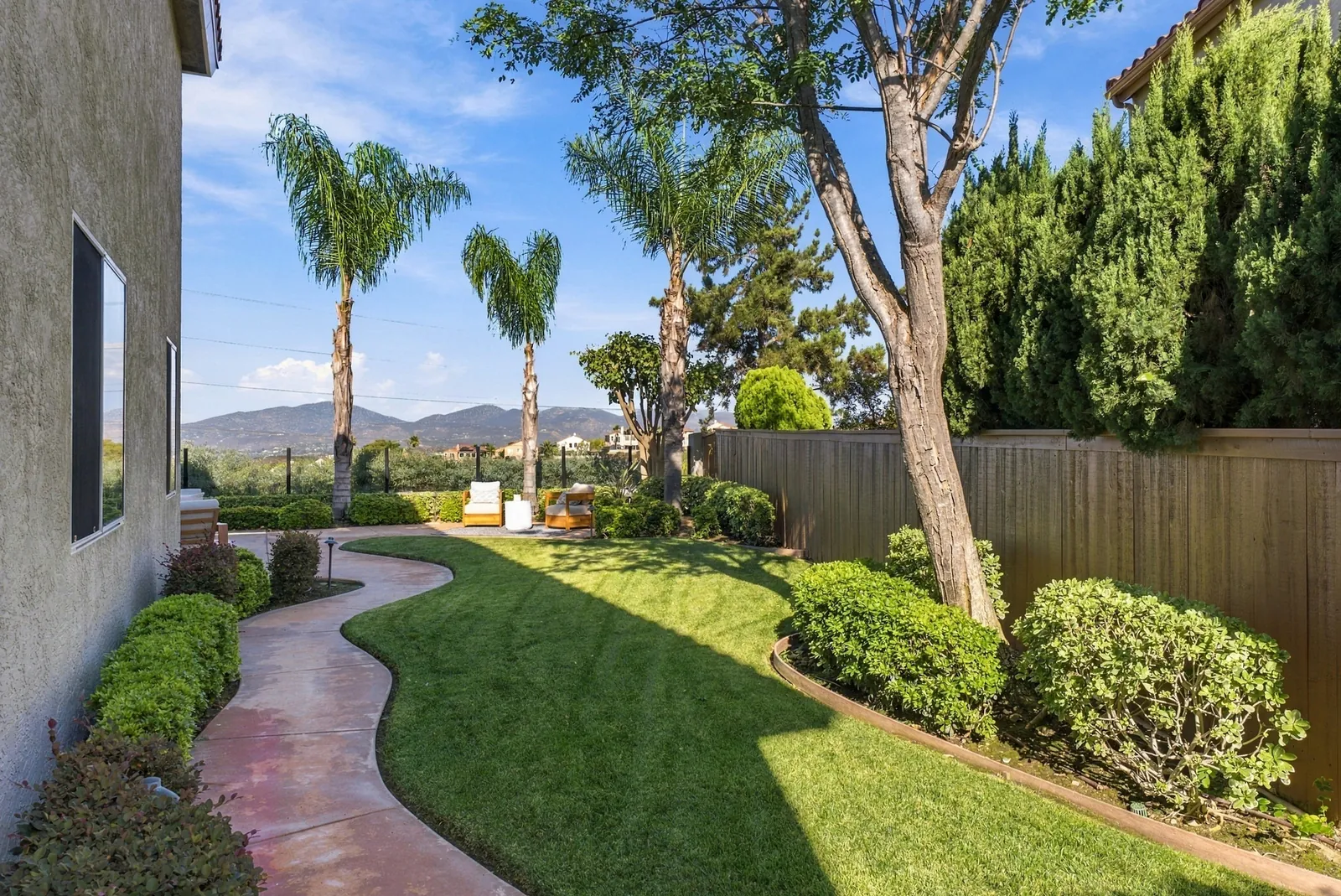 Side lawn and curving path along the house with mature landscaping at 12086 Little Silver Ct, Scripps Ranch, San Diego