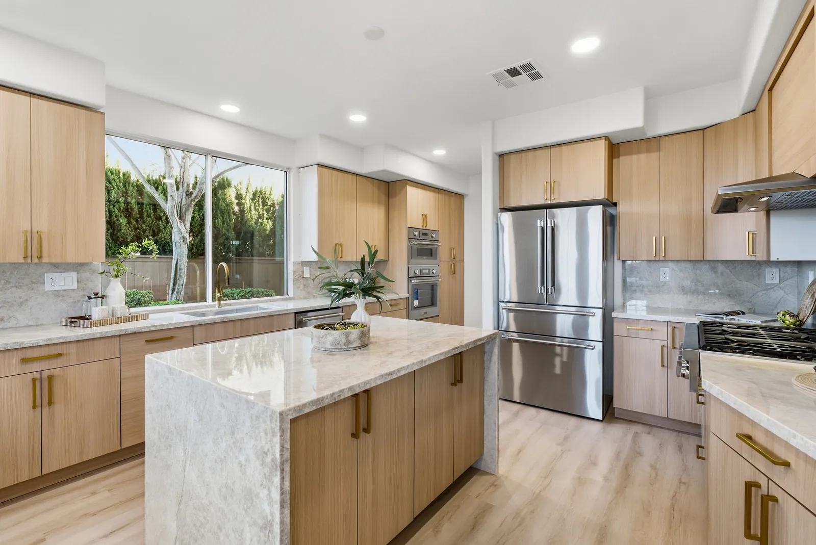 Remodeled kitchen with new light wood cabinets, quartzite waterfall island and stainless appliances at 12086 Little Silver Ct, Scripps Ranch, San Diego