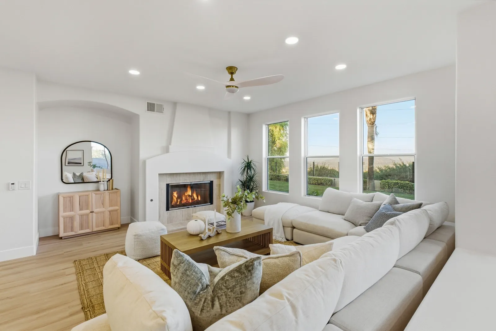 Family room with fireplace, sectional seating and windows facing the backyard at 12086 Little Silver Ct, Scripps Ranch, San Diego
