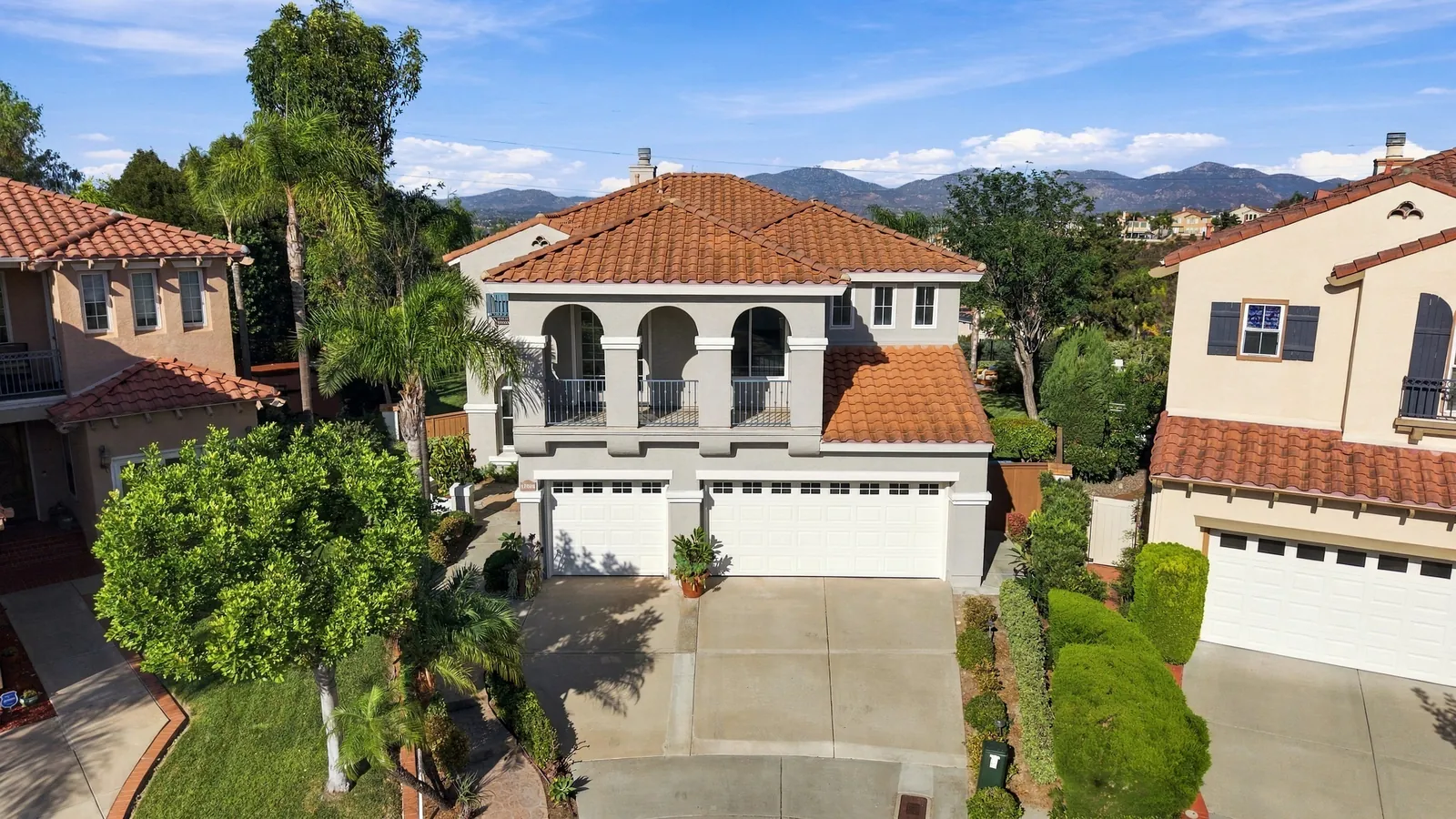 Aerial of the front of the home on the cul-de-sac with mountains in the distance at 12086 Little Silver Ct, Scripps Ranch, San Diego