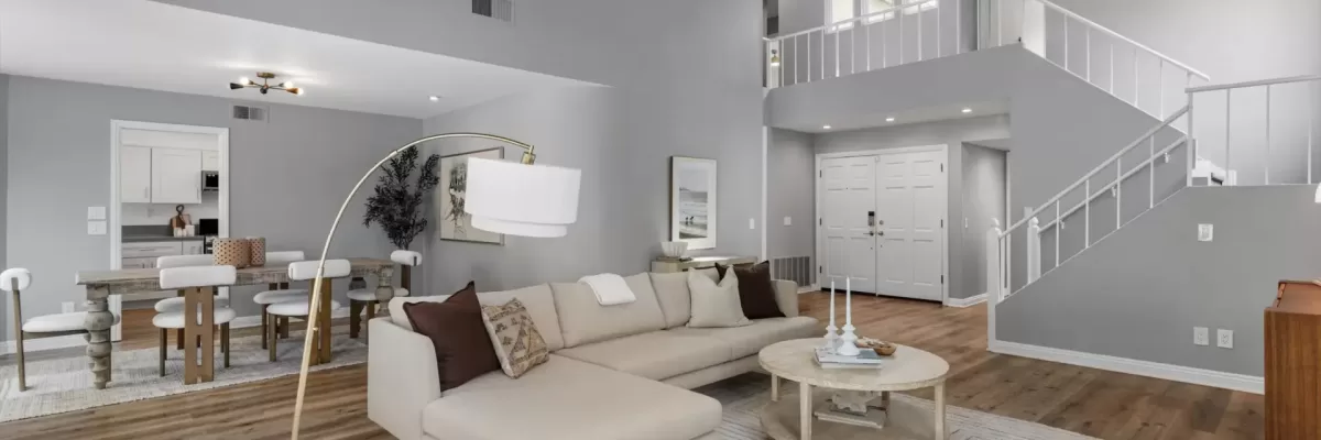 Grand living room at 1842 Bel Air Terrace, Encinitas, CA. Features double-height ceilings, a second-floor mezzanine overlook, wide-plank wood flooring, and modern neutral staging. Listed by Kelli Miller.