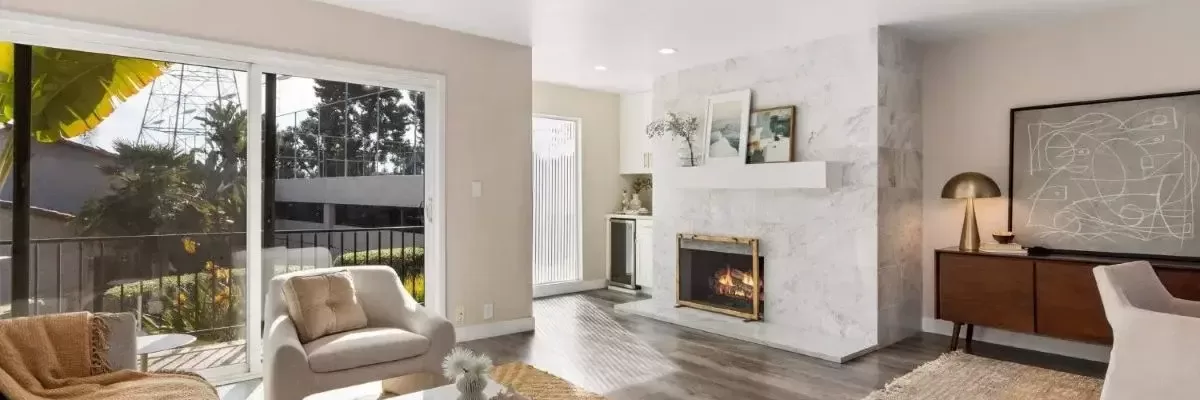 Open-concept living room with fireplace at 1913 Alga Rd Unit A townhome in Carlsbad CA.